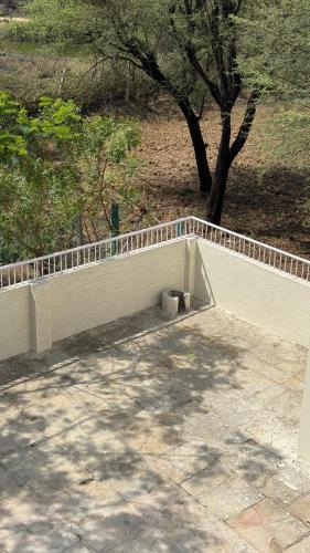 a concrete retaining wall with a fence around it at Sheopur Shikaar Oudi in Sheodāspura