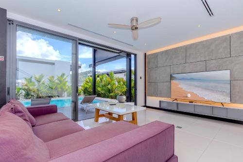 a living room with a purple couch and a tv at Loft-Style Hyper Modern 4Br Villa Sunset garden 6 with 12x5m Salt Pool in Rawai Beach