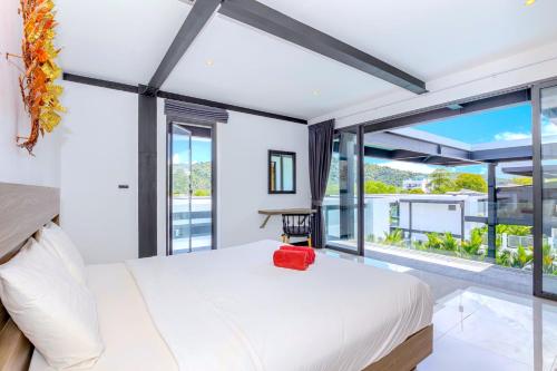 a bedroom with a white bed and large windows at Loft-Style Hyper Modern 4Br Villa Sunset garden 6 with 12x5m Salt Pool in Rawai Beach