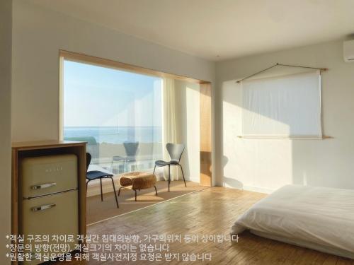 a bedroom with a bed and a view of the ocean at Gongzone Stay in Jeju