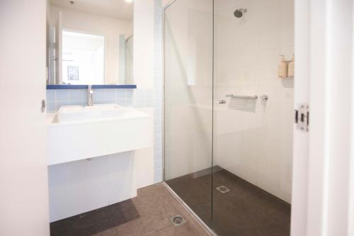 a bathroom with a sink and a glass shower at Little Drifter North Melbourne in Melbourne