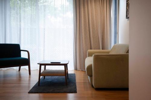 a living room with a couch and a chair and a table at Little Drifter North Melbourne in Melbourne