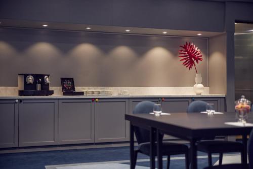 a kitchen with a table with two chairs and a vase at Kimpton De Witt Amsterdam by IHG in Amsterdam
