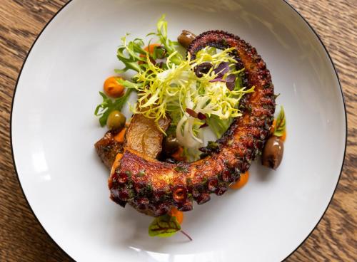 a plate with a piece of meat with a salad at Kimpton De Witt Amsterdam by IHG in Amsterdam