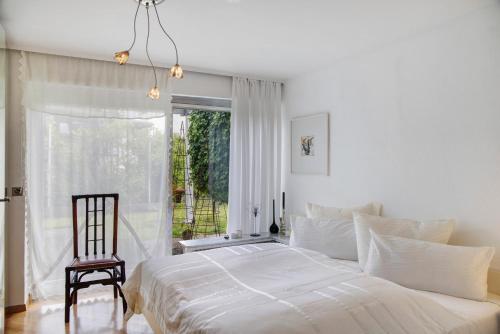 a bedroom with a bed and a chair and a window at Haus Gutschi in Imst