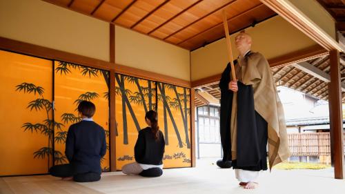 Tamba-sasayamaにある豆家mameyaのローブを着た男性が3人の少年と一緒に部屋に立っている