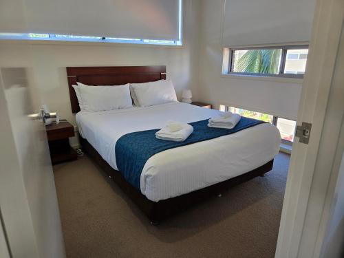 a bedroom with a bed with two towels on it at Quarterdecks Retreat in Hervey Bay