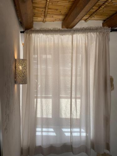 a window with a white curtain and a lamp at Spiti Anastasia in Kathikas