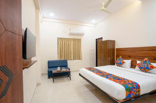 a bedroom with a bed and a tv and a chair at FabHotel Three Waves- Nr LB Nagar Metro Station in Surūrnagar