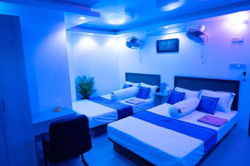 BāiljuriにあるHotel Uttaraのブルールーム ベッド2台&ソファ付