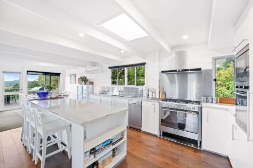 a large kitchen with white cabinets and a large island at Nature Comfort Views Dromana Family Retreat in Dromana