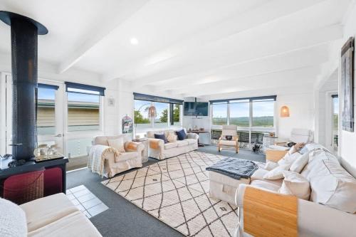 a living room with white furniture and a fireplace at Nature Comfort Views Dromana Family Retreat in Dromana