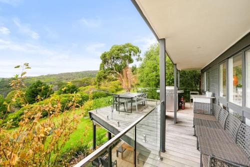 a deck with a table and benches on a house at Nature Comfort Views Dromana Family Retreat in Dromana