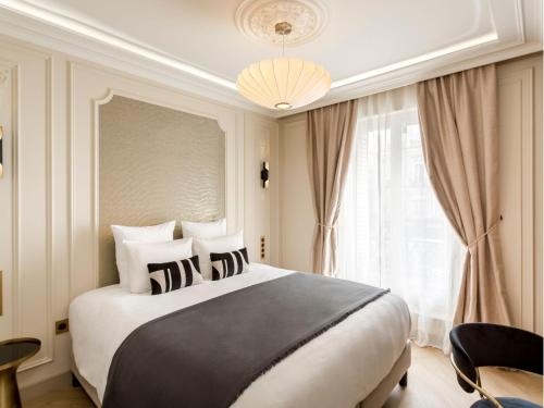 une chambre avec un grand lit et une fenêtre dans l'établissement Merveil - Luxury Suite - Marais - Turbigo II, à Paris