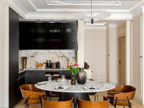 une salle à manger avec une table et des chaises blanches dans l'établissement Merveil - Luxury Suite - Marais - Turbigo II, à Paris