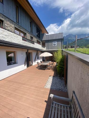 ゴイング・アム・ヴィルデン・カイザーにあるMona Apartmentのパティオ(ベンチ、パラソル付きテーブル付)