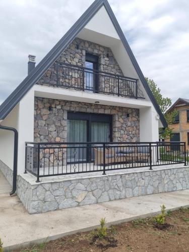 a stone house with a balcony on a building at BOK Holiday VILLAGE Kolasin in Kolašin