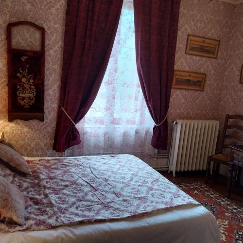 a bedroom with a bed and a window with curtains at Le coq en pâte in Bussang