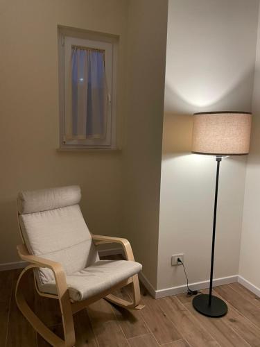 a room with a chair and a lamp and a window at Al Capannone di Pietro in Colli al Volturno