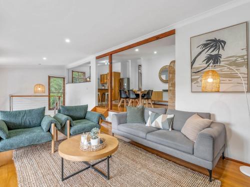 a living room with two couches and a table at The Canopy House - by Coast Hosting in Terrigal