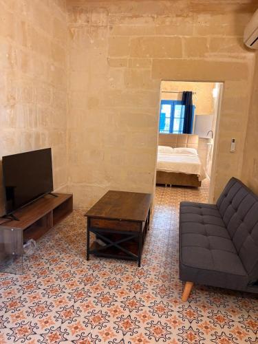 a living room with a couch and a mirror at Traditional Maltese Family Townhouse - Cospicua in Cospicua