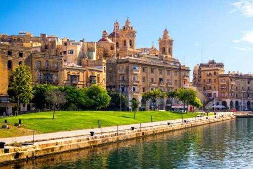 a group of buildings next to a body of water at Traditional Maltese Family Townhouse - Cospicua in Cospicua
