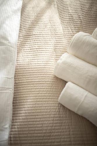a pile of white pillows on a bed at Apartmán u břehu Lipna se zahradou in Černá v Pošumaví
