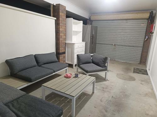 a living room with a couch and a table at YOU guest house in Barellan Point