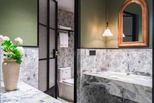 a bathroom with a sink and a toilet and a mirror at 重庆大野江景民宿 in Chongqing