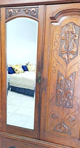 a wooden door with a mirror next to a bed at Happy'Nest at Garden Route in Riversdale