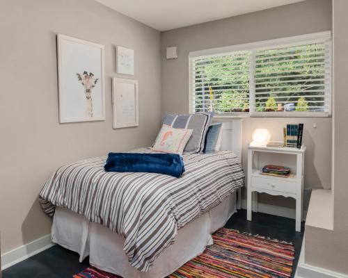 a small bedroom with a bed and a window at Spacious Main Street Retreat for families and large groups in Edmonds