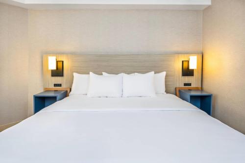 a large white bed in a hotel room at Comfort Inn in Laval