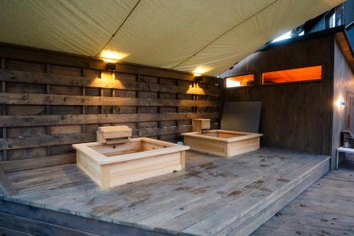 a sauna with two wooden boxes on a wooden floor at 8Lantern サウナ付き民泊で日本10位 最大10名 大きな窓とウッドデッキの一体感 2025年完成 BBQ 貸し切り宿 in Yamanakako