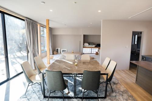 a dining room with a table and chairs at 8Lantern サウナ付き民泊で日本10位 最大10名 大きな窓とウッドデッキの一体感 2025年完成 BBQ 貸し切り宿 in Yamanakako