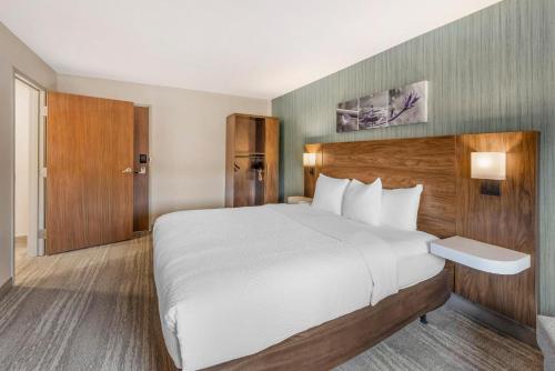 a hotel room with a large bed with white sheets at Sleep Inn Oakbrook Terrace - Chicago in Oakbrook Terrace