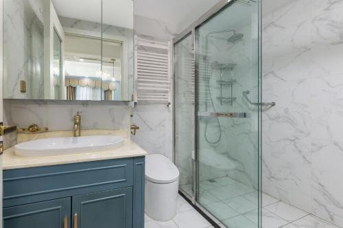 a bathroom with a sink and a glass shower at 重庆大野江景民宿 in Chongqing
