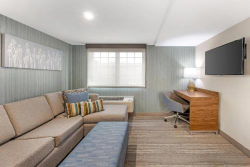a living room with a couch and a desk at Sleep Inn Oakbrook Terrace - Chicago in Oakbrook Terrace