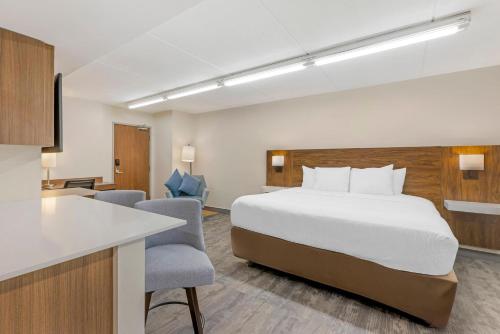 a hotel room with a bed and a kitchen at Sleep Inn Oakbrook Terrace - Chicago in Oakbrook Terrace