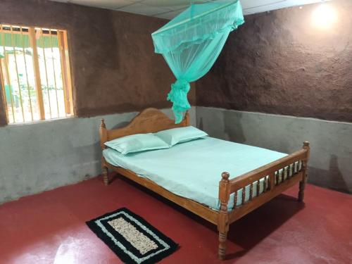 a bedroom with a bed with a blue canopy at Spice Village Hotel & Restaurant in Habarana