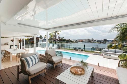 an outdoor patio with a pool and a table and chairs at MainSail by Coast Hosting in Daleys Point