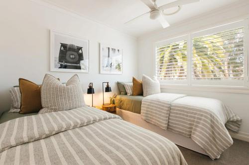 a bedroom with two beds and a couch at MainSail by Coast Hosting in Daleys Point