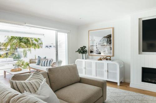 a living room with a couch and a fireplace at MainSail by Coast Hosting in Daleys Point
