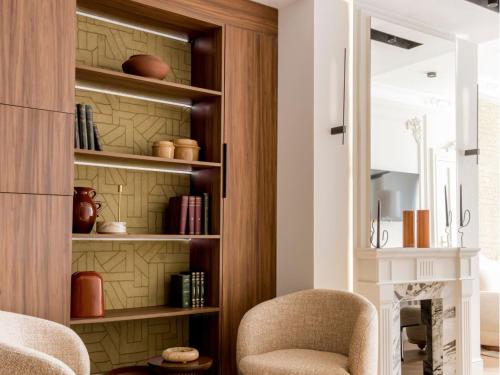 - un salon avec une chaise et une cheminée dans l'établissement Merveil - Signature Suite -Tour Eiffel-Grenelle II, à Paris