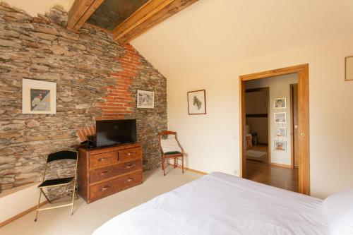 a bedroom with a bed and a stone wall at CHATEAU du PERRAY in Saint-Mars-du-Désert