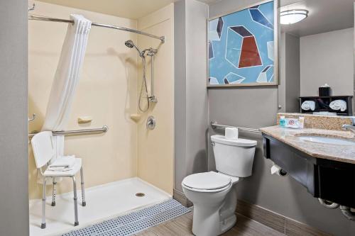 a bathroom with a toilet and a shower and a sink at Comfort Inn in Cadillac