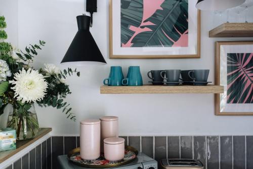 a kitchen with pink and blue items on a stove at Palm House by Coast Hosting in Terrigal