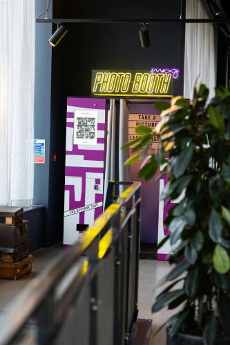 a store front with a photo booth sign and a potted plant at Moxy Chester in Chester