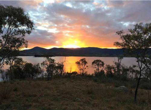 a sunset over a lake with trees in the foreground at Flow Rider #6 in Jindabyne