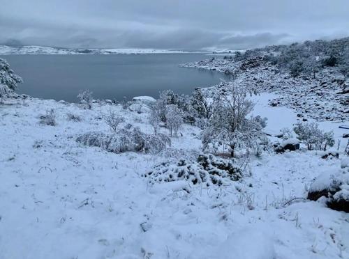 a snow covered field with a body of water at Flow Rider #6 in Jindabyne