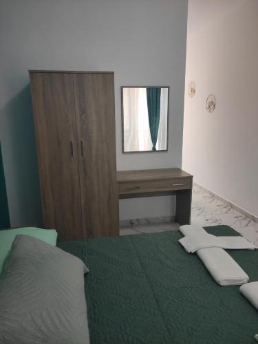 a bedroom with a bed and a dresser with a mirror at Apollon Stegna Studios in Archangelos